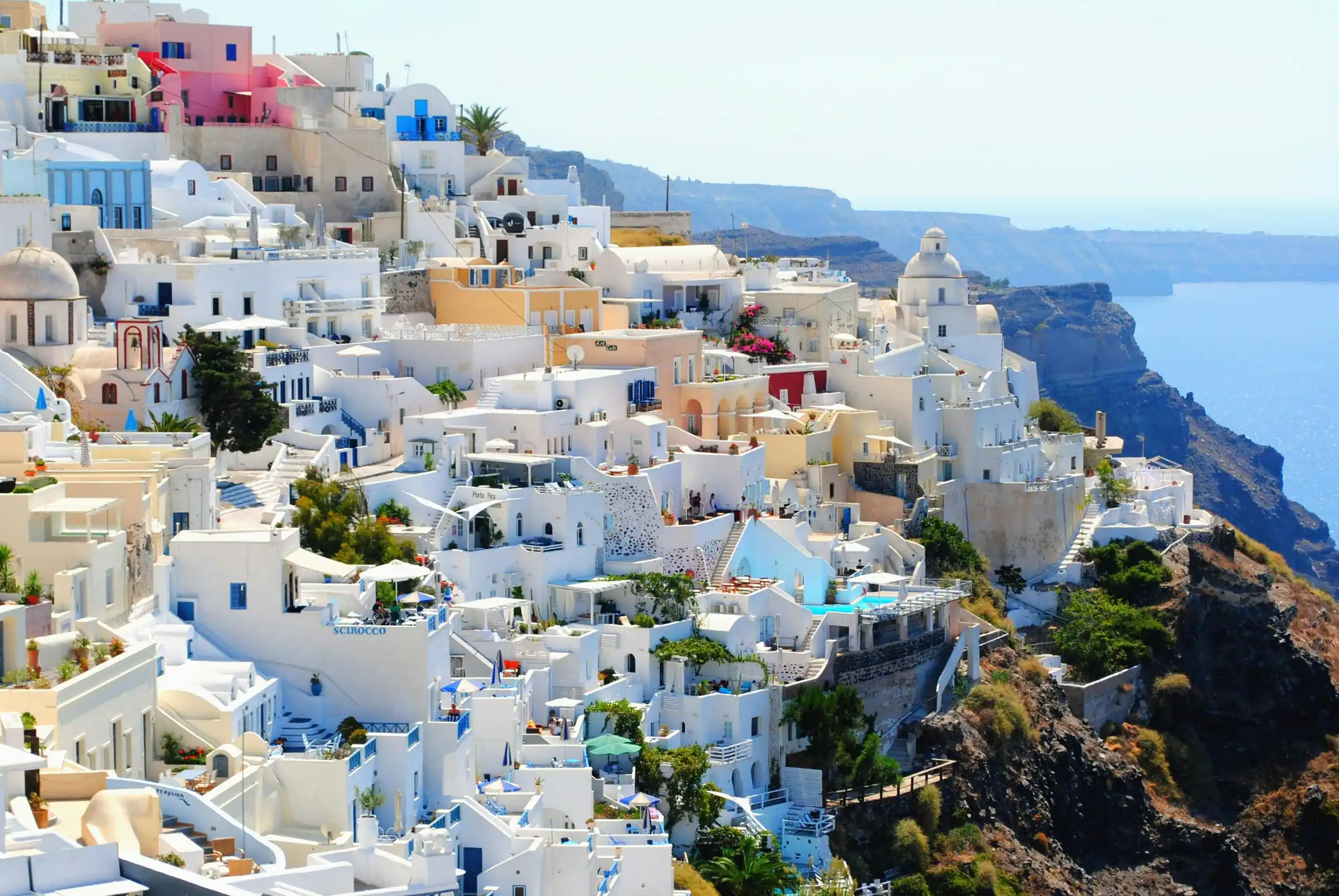 Blue-domed churches and Aegean Sea cliffs in Santorini, Greece — Greek islands honeymoon and island hopping